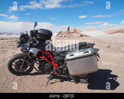 Una motocicletta di fronte alla formazione rocciosa Las Tres Marias in Cile Foto Stock