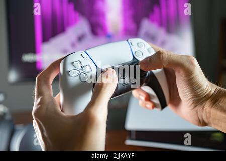 Bangkok, Thailandia - 27 luglio 2022: Giocatore che gioca alla console di gioco PlayStation 5 con il controller DualSense. Foto Stock
