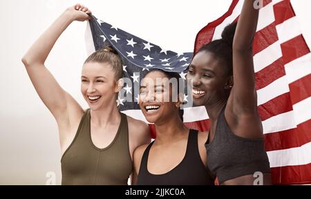 L'unica squadra di cui hai bisogno al tuo fianco. Una giovane squadra sportiva che tiene la bandiera americana. Foto Stock