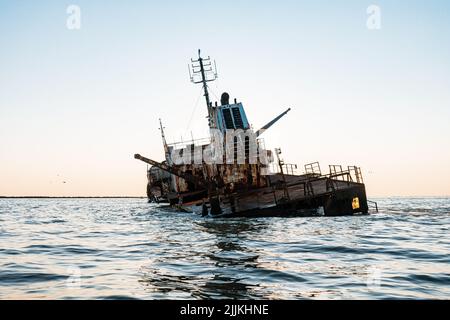 Un colpo verticale di un relitto nel ramo Sulina del Delta del Danubio contro un cielo senza nuvole Foto Stock