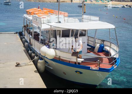 Una persona su un traghetto per la Laguna Blu a Malta Foto Stock