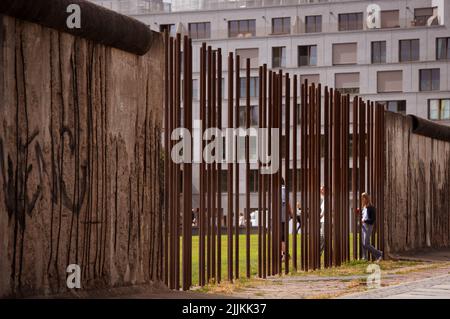 Berlino, Germania. 27th luglio 2022. Un visitatore cammina tra gli acciai presso l'ex muro di confine fino al parco del Muro di Berlino Memorial Bernauer Strasse. Credit: Paul Zinken/dpa/Alamy Live News Foto Stock