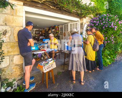 Turisti che guardano bric-a-brac in vendita garage in Angles-sur-l'Anglin, Vienne (86), Francia. Foto Stock