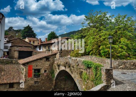 Un ponte di pietra vicino case in Potes rurale in Spagna Foto Stock