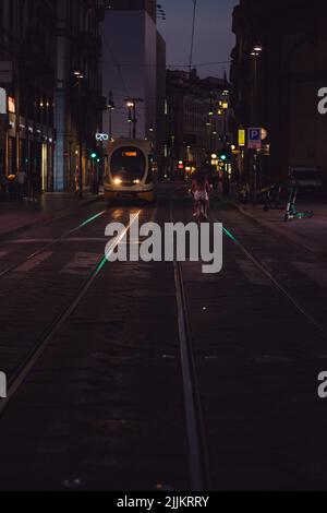 Un tram in Via Orefici nel centro di Milano che si avvicina alla fermata all'alba Foto Stock