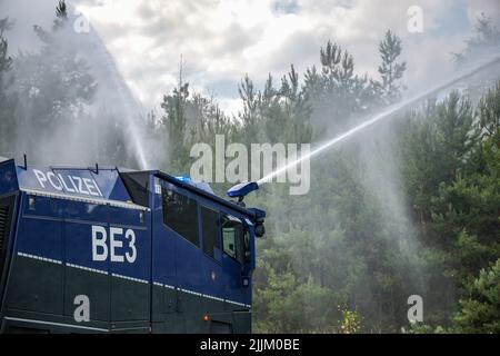 Falkenberg, Germania. 27th luglio 2022. Un cannone d'acqua della polizia di Brandeburgo estingue un incendio nella foresta. I vigili del fuoco di Brandeburgo continuano a combattere un grande incendio boschivo nel distretto di Elbe-Elster. Da lunedì (25.07.2022) brucia su una superficie di 800 ettari. Le aree sono parzialmente contaminate da munizioni. Questo complica il lavoro di estinzione degli incendi. Credit: Jan Woitas/dpa/Alamy Live News Foto Stock