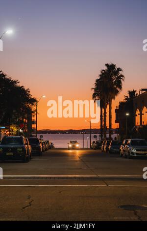 Un colpo verticale di auto con un oceano Atlantico sullo sfondo al tramonto a Punta del Este, Uruguay Foto Stock