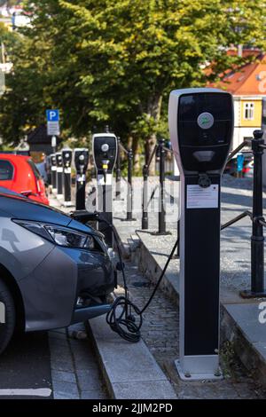 Una Toyota elettrica grigia collegata al caricabatterie della centrale elettrica Foto Stock