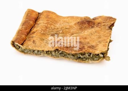 Fetta di torta ligure verde, dolce tipico italiano salato ligure ripieno di zucchine e riso, cipolle e porri. Isolato su bianco Foto Stock