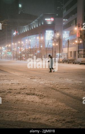 La gente nelle strade della città in inverno di notte Foto Stock