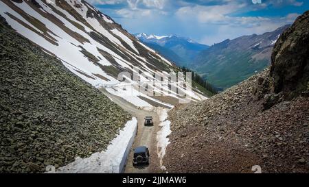 Uno scatto aereo di una Jeep Wrangler e un Hummer H3 off-roading nelle montagne di Ouray, Colorado Foto Stock