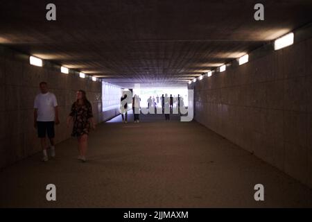 Persone che camminano attraverso un tunnel nel centro della città di Monaco Foto Stock