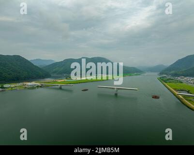 Strada incompiuta sul ponte in costruzione sul fiume nella città di montagna Foto Stock