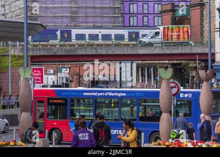 Il centro città di Warrington è molto trafficato, con il treno che arriva alla stazione centrale e la strada del cavalcavia passando per il centro e un autobus locale che si ferma a Foto Stock