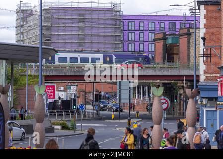 Il trafficato centro cittadino di Warrington con il treno che arriva alla stazione centrale e la strada del cavalcavia passando per il centro. Foto Stock