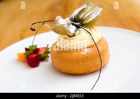 Un babà al rum o baba au rhum al rum è una piccola torta di lievito saturata in sciroppo fatta con liquore duro, solitamente rum, e talvolta riempita con panna montata o pas Foto Stock