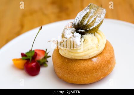 Un babà al rum o baba au rhum al rum è una piccola torta di lievito saturata in sciroppo fatta con liquore duro, solitamente rum, e talvolta riempita con panna montata o pas Foto Stock