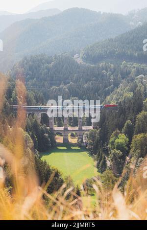 Vista del viadotto ferroviario di Kalte Rinne e del treno di transito a Semmering, Gruppo Rax-Schneeberg, Stiria, Austria. Foto Stock