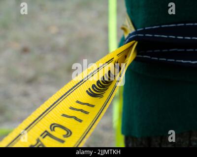 Mindfulness Slackliner Man Crossing a Tightrope in un parco durante un tramonto soleggiato. Foto Stock