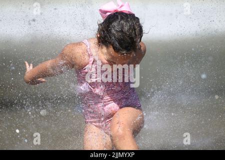 Raleigh, Carolina del Nord, Stati Uniti. 27th luglio 2022. ROSIE DILDAY, 4 anni, si raffredda passando attraverso gli sprinkler a spruzzi nel John Chavis Memorial Park, quando le temperature raggiungeranno nuovamente la metà degli anni '90 a Raleigh, NC. Gran parte del paese ha anche sperimentato temperature superiori alla media per tutto il mese di luglio. (Credit Image: © Bob Karp/ZUMA Press Wire) Foto Stock