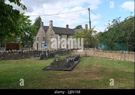 Villaggio Pound nel villaggio di Oxfordshire di Ascott sotto Wychwood con la casa pubblica del villaggio il Swan nella parte posteriore. Le pietre sono un monumento al Foto Stock