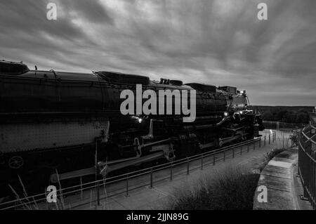 Una foto in scala di grigi della locomotiva Union Pacific Big Boy in mostra contro il cielo nuvoloso nel Nebraska, Stati Uniti Foto Stock