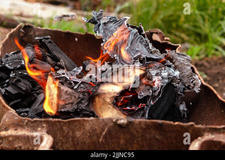 Legno che brucia. Il resto dell'alveare. Legna da ardere. Ceneri nel cavoldro. Resti del fuoco. Foto Stock