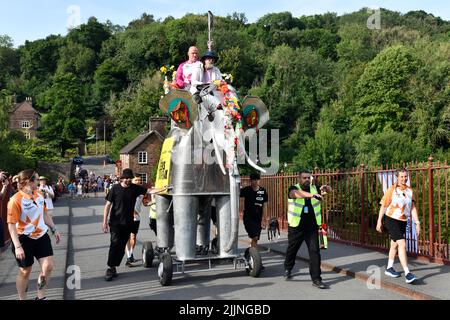 Queen's Baton Relay. Il Commonwealth Games Queen's Baton Relay attraversa l'Ironbridge su un elefante meccanico. Foto Stock