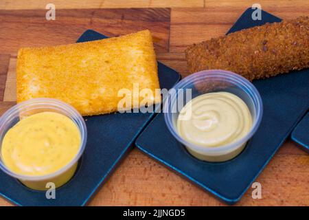 Una vista dall'alto di due tipi di pepite croccanti fritte con salse a parte Foto Stock