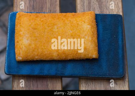 Una vista dall'alto del pepato croccante di pollo fritto su un piatto nero Foto Stock