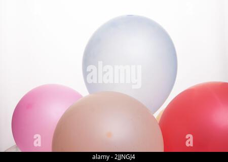 Un primo piano dei palloncini colorati sullo sfondo bianco Foto Stock