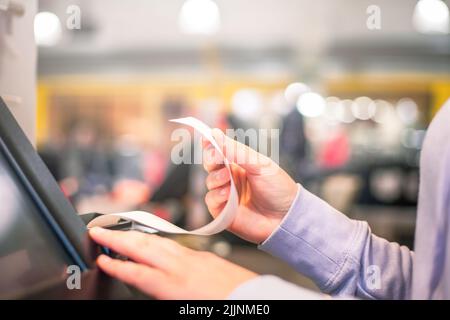 Venditore o acquirente che stampa una ricevuta o una fattura per un cliente, tempo di vendita, periodo di sconto, concetto POS Foto Stock