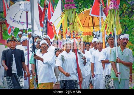 Un gruppo di indù balinesi che svolgono una cerimonia per strada Foto Stock