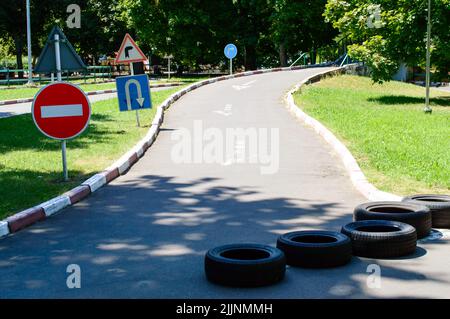 Segnaletica stradale - senza ingresso, inversione, Gira a destra. Pneumatici in gomma su strada. Autodromo nel parco. Foto Stock