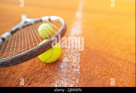 Primo piano di racchette e palle in terra di terra o campo da tennis, concetto sportivo Foto Stock