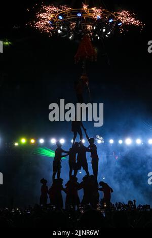 Uno scatto verticale di uno spettacolo di luce laser durante il festival indiano di Dahi Handi, Pune, Maharastra Foto Stock