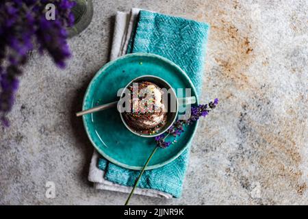 Vista dall'alto di una tazza di cioccolato fatto in casa e gelato alla vaniglia con spolverini Foto Stock