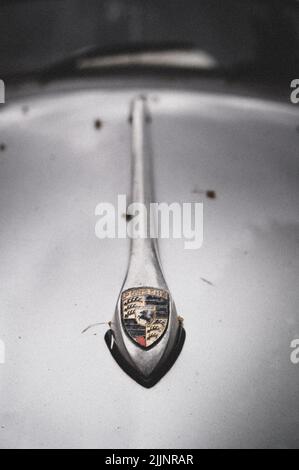 Un primo piano del logo Porsche sul cofano dell'auto Foto Stock