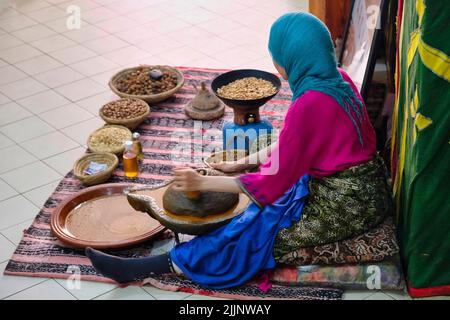 Donna artigiana che produce olio di argan in Marocco Foto Stock