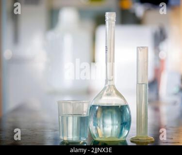 Migliorare la sicurezza del laboratorio. Matraccio, becher e cilindro in plastica per la sostituzione del vetro in un laboratorio di chimica. Foto Stock