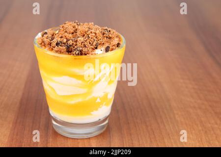 Piccolo bicchiere di limone con mousse di mascarpone su un tavolo di legno Foto Stock