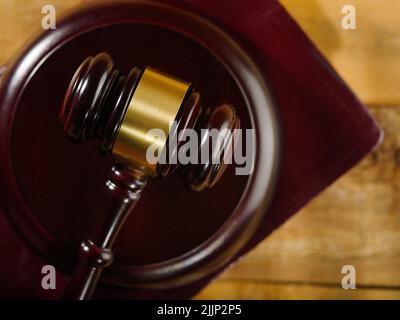 Scatto macro. Il gavel del giudice del mogano. Isolato su sfondo di legno. Un simbolo di un processo equo e onesto. Courtroom, asta. Pubblicità, poster, divieto Foto Stock