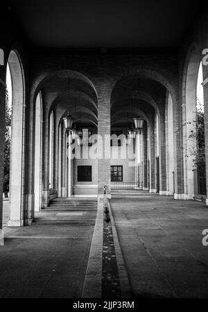 Un'immagine verticale in scala di grigi dell'architettura dei corridoi a Madrid, Spagna Foto Stock