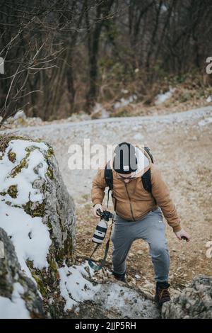 Un giovane turista con uno zaino e una macchina fotografica che cammina nella natura Foto Stock
