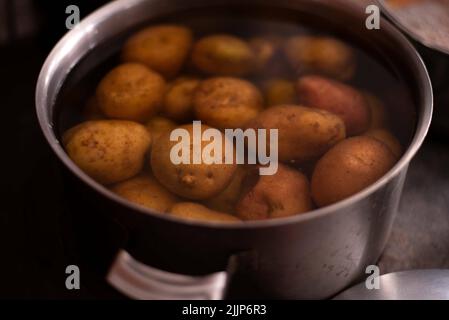 Le patate che bollono in una pentola Foto Stock