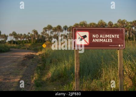 31 dicembre 2021, Parco Nazionale El Palmar, Entre Rios, Argentina: Segno sul lato di una strada sterrata con il messaggio non dare da mangiare agli animali Concepti: ecologica Foto Stock