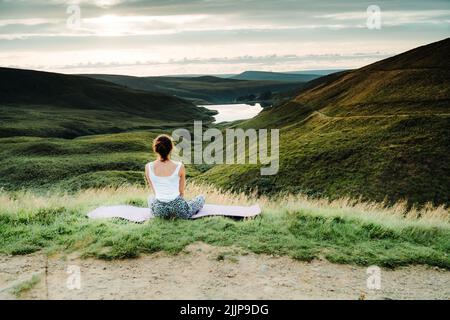 Wessenden Head Reservoir visto dal drone, donna che guarda il tramonto al Peak District National Park durante l'estate, Inghilterra, Regno Unito Foto Stock