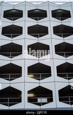 Un colpo verticale di un edificio bianco urbano con finestre geometriche nere a forma di motivo Foto Stock