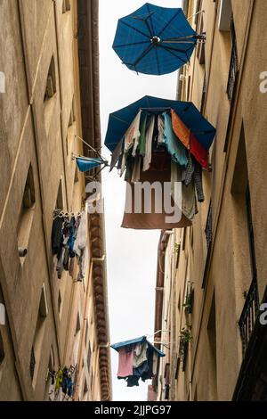 Un colpo verticale di vestiti colorati appesi sulla corda fuori nella città di Bilbao in Spagna Foto Stock