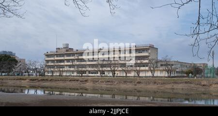 Kasukabe Municipal Midori Junior High School durante il COVID-19. Aule principali, situate sul fiume Furutone in una nuvolosa mattinata invernale. Foto Stock